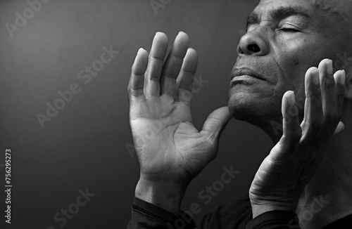 black man praying to god with hands together Caribbean man praying on black background with people stock photos stock photo 