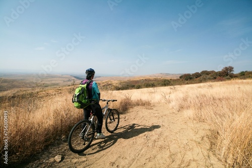 A cyclist admires the view of the steppe, Russia.