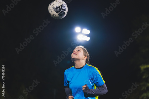 medium shot of a school-age soccer player girl throwing a ball up in the air, sport and girls concept. High quality photo