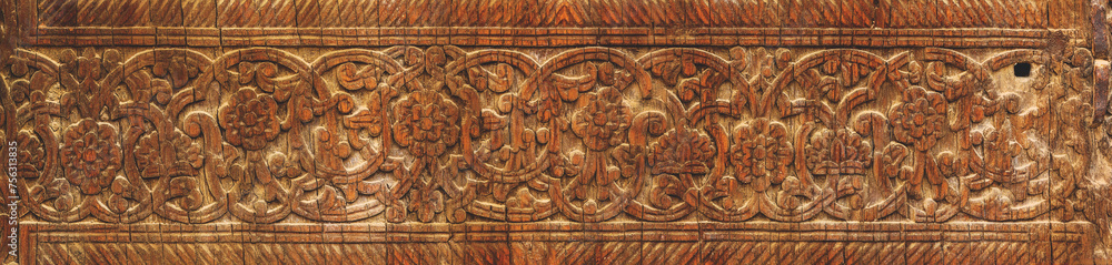 Elaborate wooden carving depicting traditional floral patterns in a warm, rich brown tone. Khiva (Xiva), Turkey (Turkiye)