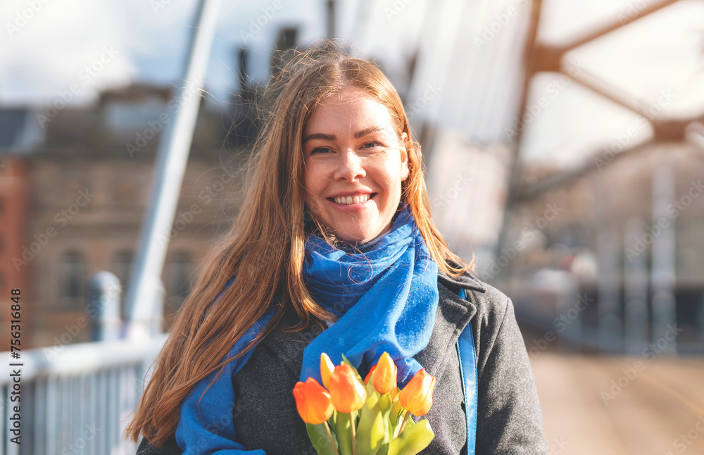 Portrait of happy woman with tulips  having a fun day, walking around an English city Lifestyle, tourism,  world woman's day concept - obrazy, fototapety, plakaty 
