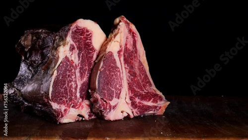 il macellaio taglia la bistecca con il coltello affilato.
in macelleria: Primo piano della carne rossa da cuocere alla griglia. photo