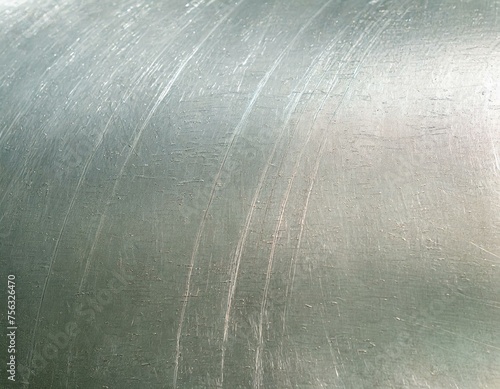 Close-up of an aluminum surface with a pattern of fine scratches, highlighting the metal's resilience and wear over time.