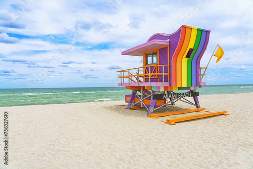  Vibrant, pastel view of lifeguard tower colorful painted as LGBT flag under bright blue sky on South Beach, Miami, Florida. © Igor