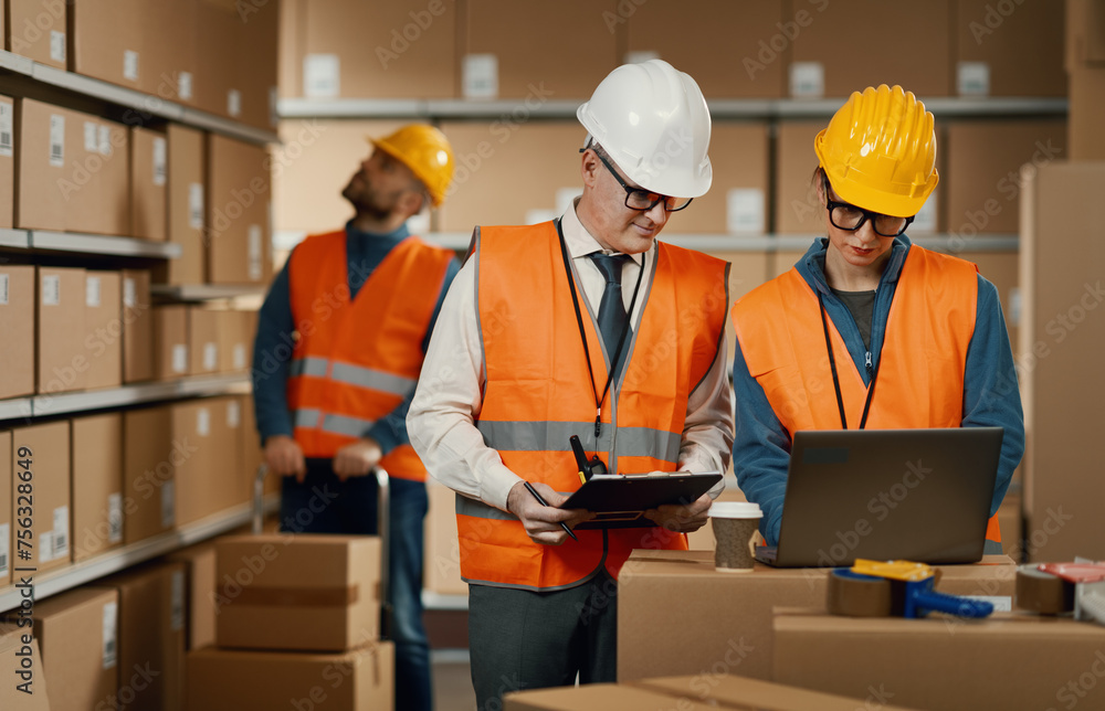 Warehouse workers checking orders on the laptop Warehouse workers checking orders on the laptop