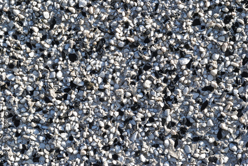 Close Up of Black and White Pebbles on Textured Exterior Wall of Building