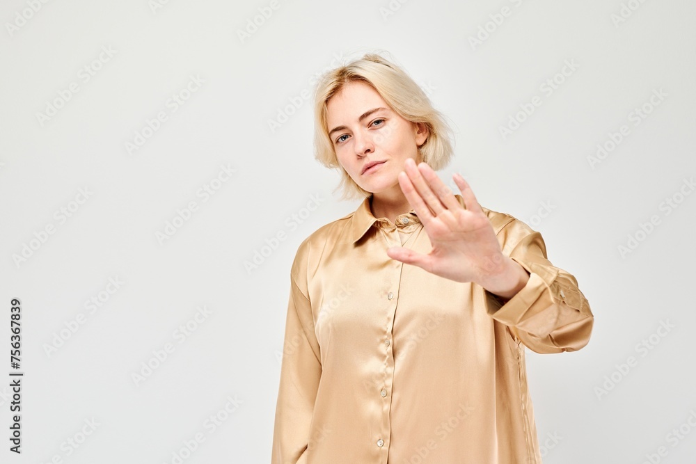 Blonde woman gesturing stop with hand, expressing denial or rejection, isolated on white background. Blonde woman gesturing stop with hand, expressing denial or rejection, isolated on white background.