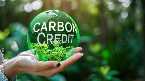 A person is holding a globe with the word Carbon Credit written on it photo