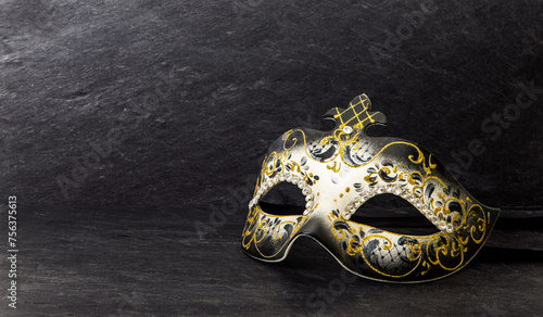 Venetian carnival mask on dark slate background.