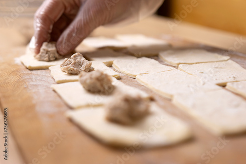 Pieces of meat are laid out on the puff pastry. Preparation of meat pies from puff pastry.
