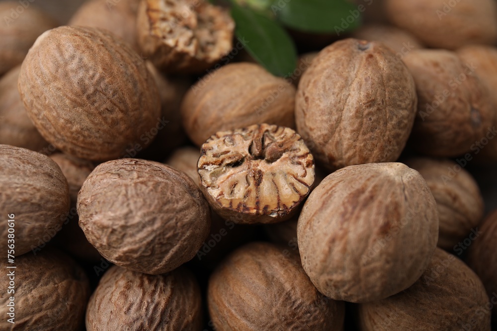 Whole and cut nutmegs as background, closeup Whole and cut nutmegs as background, closeup