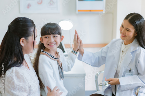 The doctor gave the little girl strength by touching her hand while her mother looked after her and gave her encouragement.