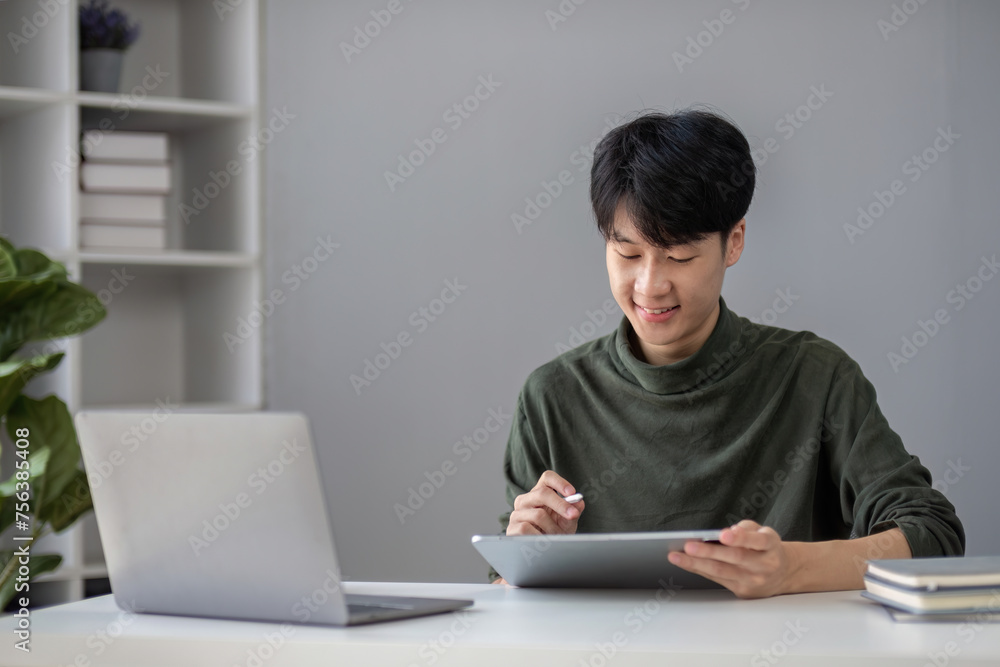 Portrait of a handsome young office worker intently studying how to do a presentation project on a laptop in his office. Portrait of a handsome young office worker intently studying how to do a presentation project on a laptop in his office.