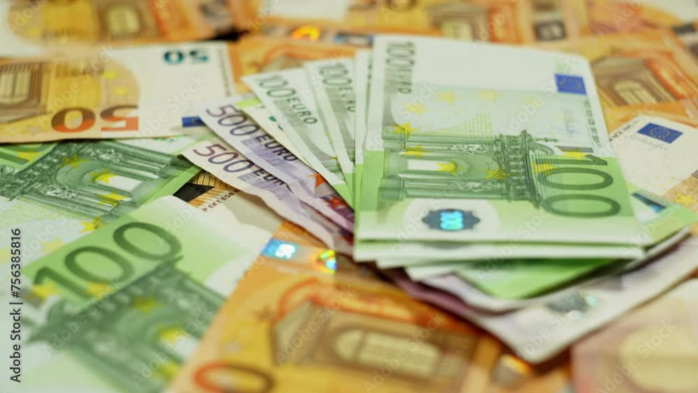 A stack of green and yellow euro banknotes neatly arranged on a table, showcasing the beauty of currency font. Money handling and saving in different currencies like dollar and cash A stack of green and yellow euro banknotes neatly arranged on a table, showcasing the beauty of currency font. Money handling and saving in different currencies like dollar and cash
