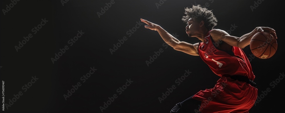 A dynamic action shot of a young professional basketball player isolated on a black background, capturing the energy and motion of the sport from a low angle.