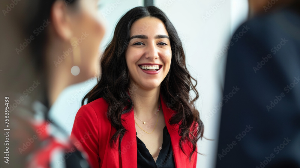 Joyful woman in a red blazer laughing during a cordial conversation. Joyful woman in a red blazer laughing during a cordial conversation.