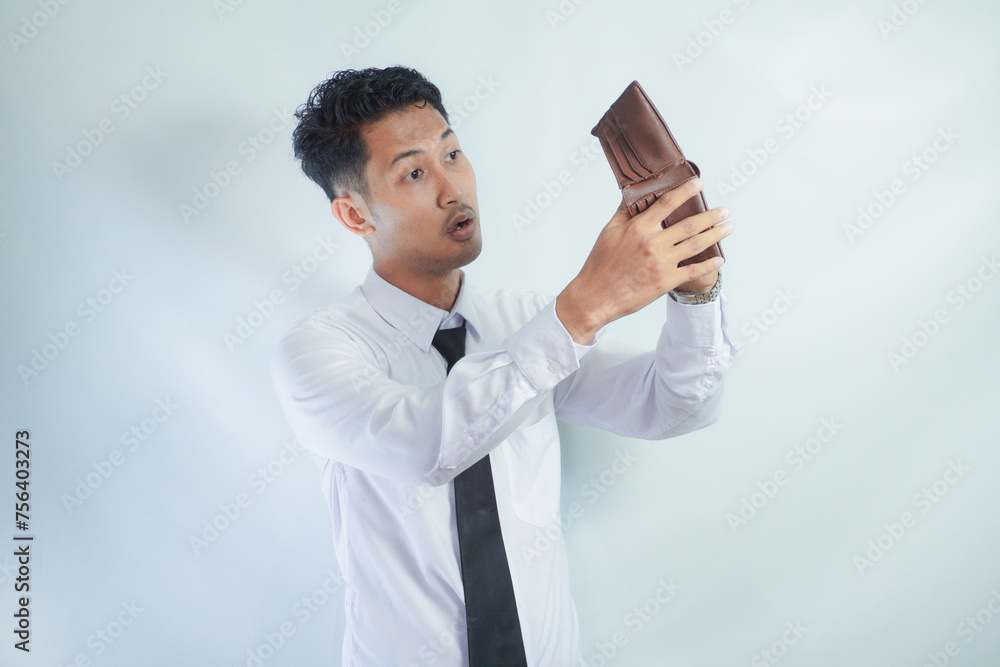 Adult Asian man showing shocked expression when looking to his empty wallet Adult Asian man showing shocked expression when looking to his empty wallet