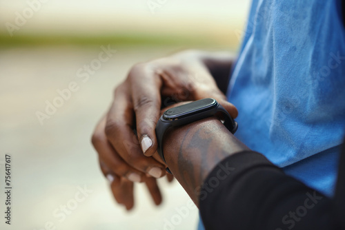 Closeup mage of sportsman checking fitness tracker after game of streetball