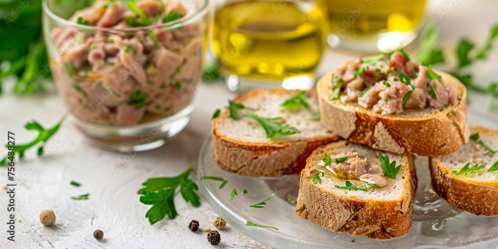 dry tuna pate, in glassware with little toasts and olive oil rosemary on a light background dry tuna pate, in glassware with little toasts and olive oil rosemary on a light background