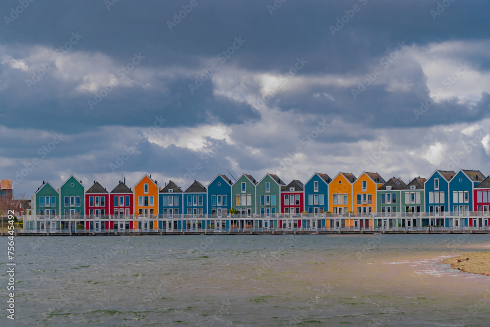 Colourful wooden lakeside houses De Rietplas. Modern residential architecture in Houten, The Netherlands
