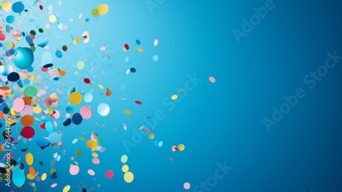 Festive multicolored confetti flying on a blue background from the copy space.