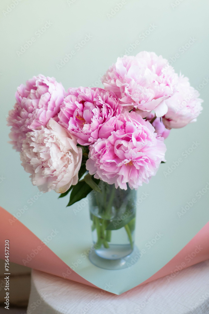 pink flowers in vase and mint color paper background