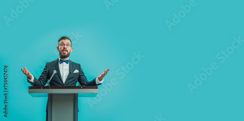 homme en train de faire un discours derrière un pupitre - fond bleu