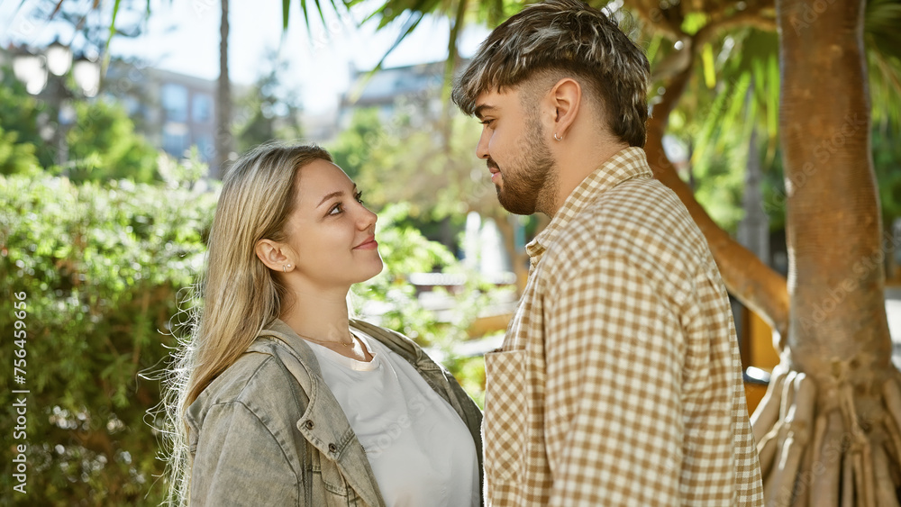 A loving couple enjoys a sunny day outdoors surrounded by greenery in a peaceful city park. A loving couple enjoys a sunny day outdoors surrounded by greenery in a peaceful city park.