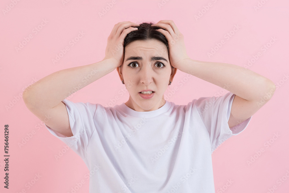 Shocked or stressed attractive caucasian young brunette woman in casual clothing, looking nervously at the camera isolated on a pink studio background. Shocked or stressed attractive caucasian young brunette woman in casual clothing, looking nervously at the camera isolated on a pink studio background.