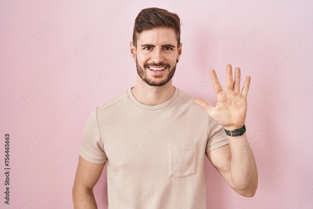 Hispanic man with beard standing over pink background showing and pointing up with fingers number five while smiling confident and happy. Hispanic man with beard standing over pink background showing and pointing up with fingers number five while smiling confident and happy.