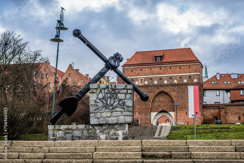 Anchor monument and Monastery Gate, entrance to historic part of Torun city, Poland photo