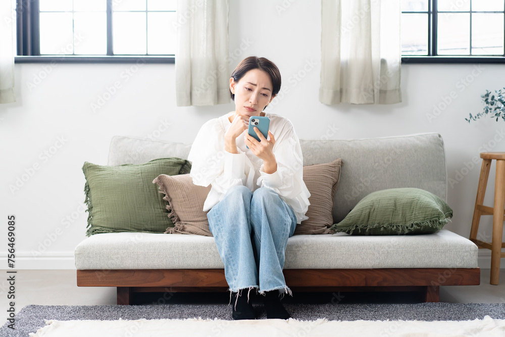 スマホを見て悩む女性 スマホを見て悩む女性