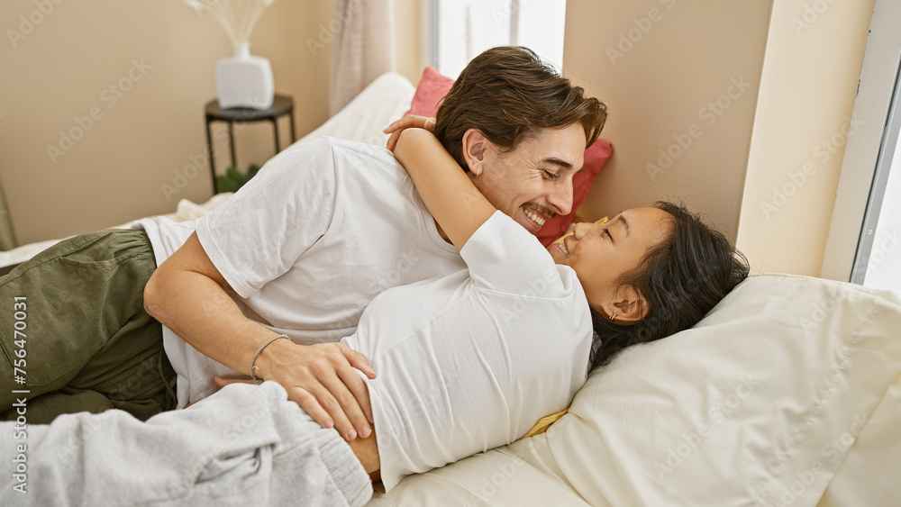 Intimate interracial couple embracing lovingly on a cozy bedroom bed, evoking romance and togetherness in a home setting. Intimate interracial couple embracing lovingly on a cozy bedroom bed, evoking romance and togetherness in a home setting.