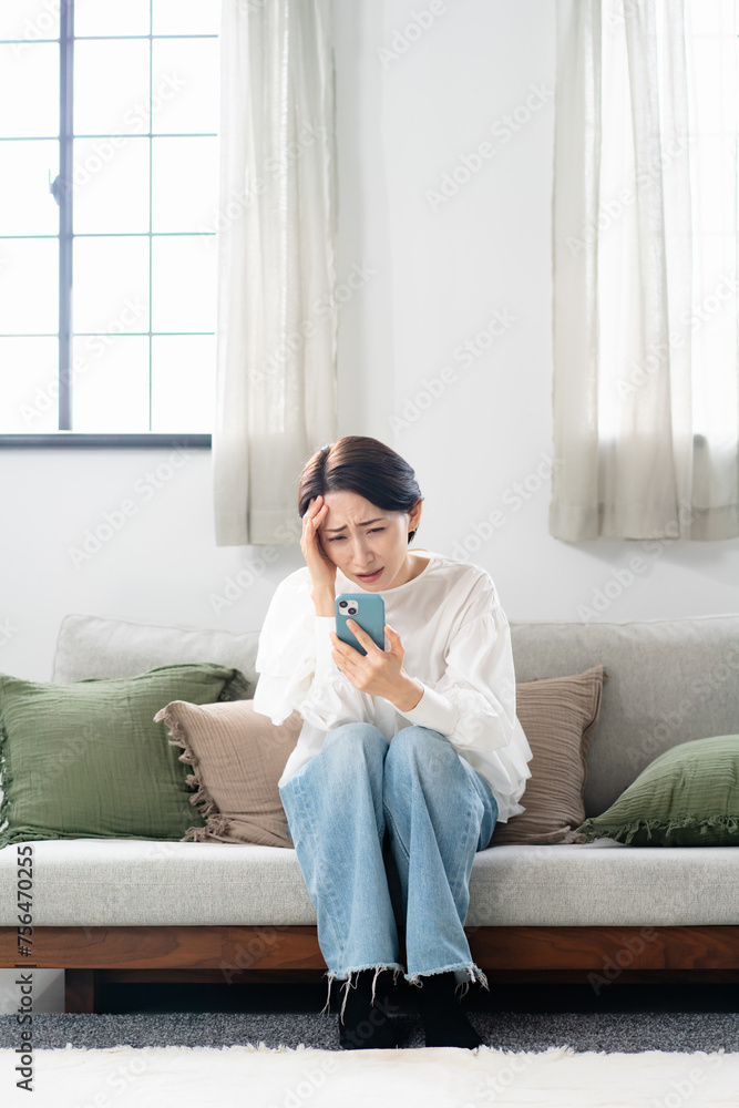 スマホを見て悩む女性 スマホを見て悩む女性