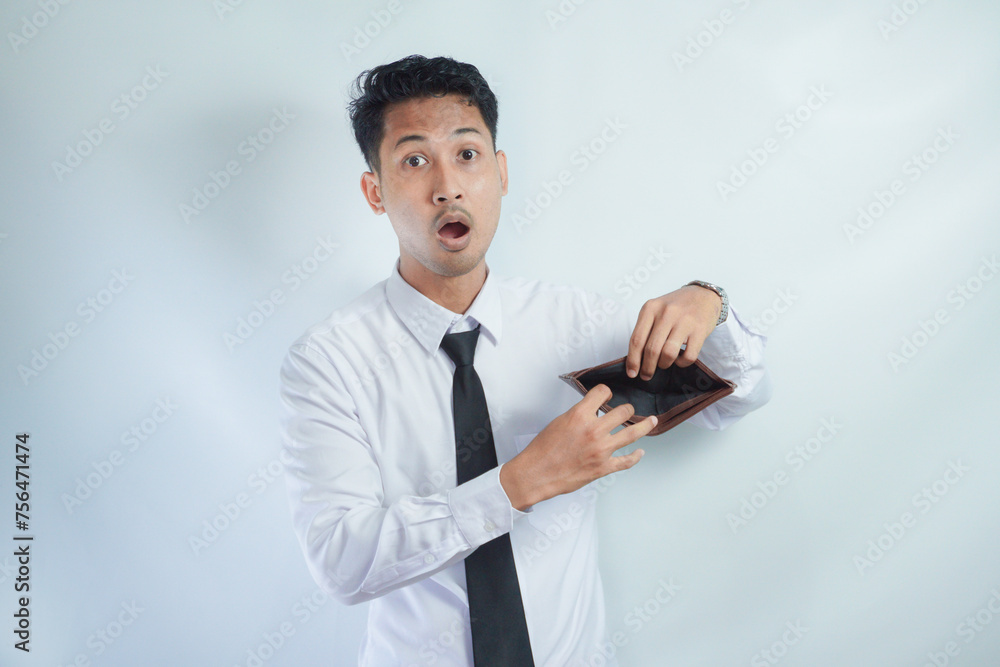 Adult Asian man showing his empty wallet with worried expression Adult Asian man showing his empty wallet with worried expression