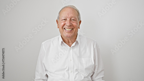 Casual snapshot of a cheerful, smiling senior man, full of confidence and joy, standing against an isolated white background, radiating happiness in his mature lifestyle.