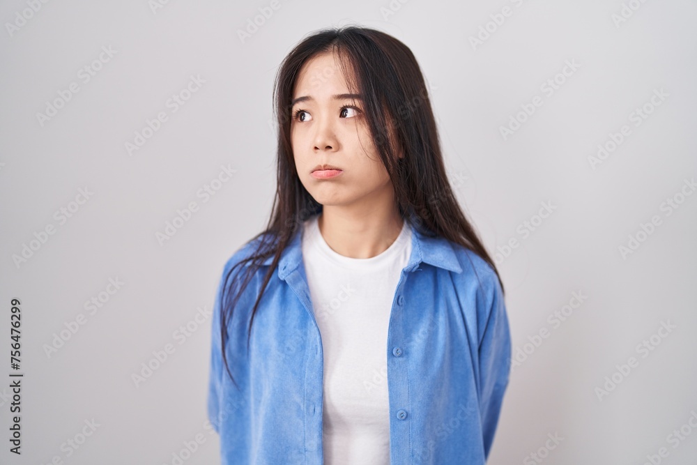 Young chinese woman standing over white background looking sleepy and tired, exhausted for fatigue and hangover, lazy eyes in the morning. Young chinese woman standing over white background looking sleepy and tired, exhausted for fatigue and hangover, lazy eyes in the morning.