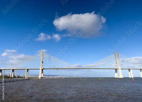 Vasco da Gama Bridge from Lisbon, Portugal, over Tagus river during a beautiful sunny day with blue sky and white clouds. Impressive bride construction.