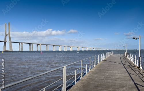 Vasco da Gama Bridge from Lisbon, Portugal, over Tagus river during a beautiful sunny day with blue sky and white clouds. Impressive bride construction. © Dragoș Asaftei