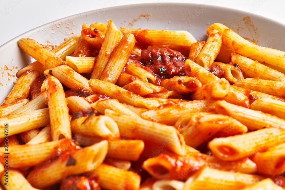 Close-up view of delicious penne pasta in tomato sauce on a ceramic plate, italian cuisine. Close-up view of delicious penne pasta in tomato sauce on a ceramic plate, italian cuisine.
