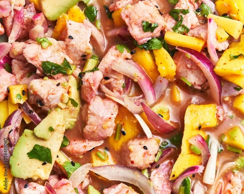 Close-up view of a colorful ceviche dish with mango, avocado, onions, and seafood giving a fresh, tropical vibe.