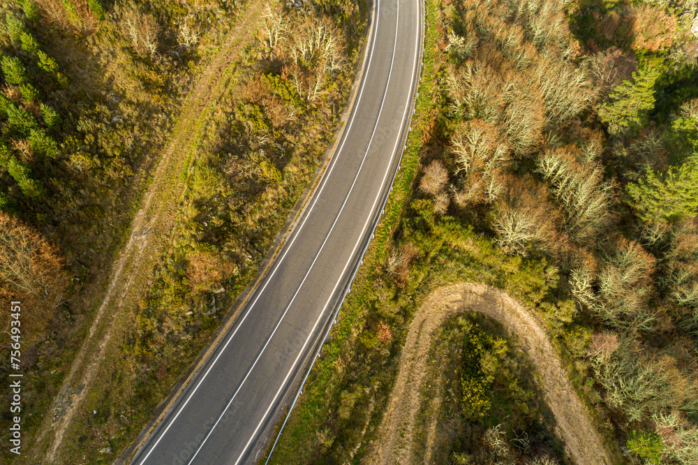 aerial top view from a drone of a mountain road at sundown