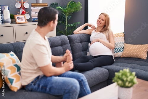 Man and woman couple expecting baby massaging feet at home