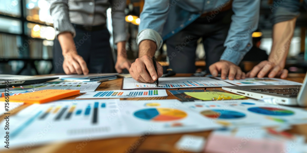 Diverse Team of Business Professionals Analyzing and Discussing Graphs and Documents During Meeting in Office Setting Diverse Team of Business Professionals Analyzing and Discussing Graphs and Documents During Meeting in Office Setting