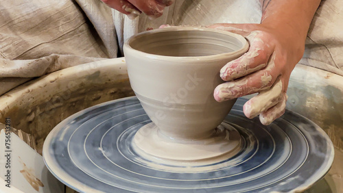 Modeling pottery with clay on pottery wheel. Hands close up, cercamic workshop