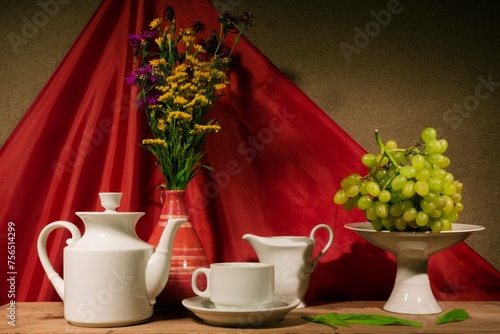 Still life of flowers - summer blooming stems of plants. Draped background - theatrical stage lighting