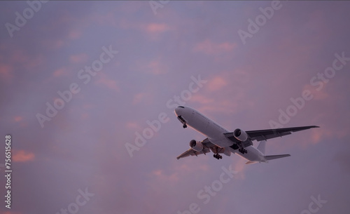 Close-up of Large airliner with passengers is flying on purple sky of bright sunset on sunny summer day. Go Everywhere.