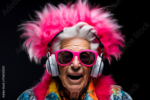 Cool grandma. Elderly woman listens to music on headphones © EwaStudio