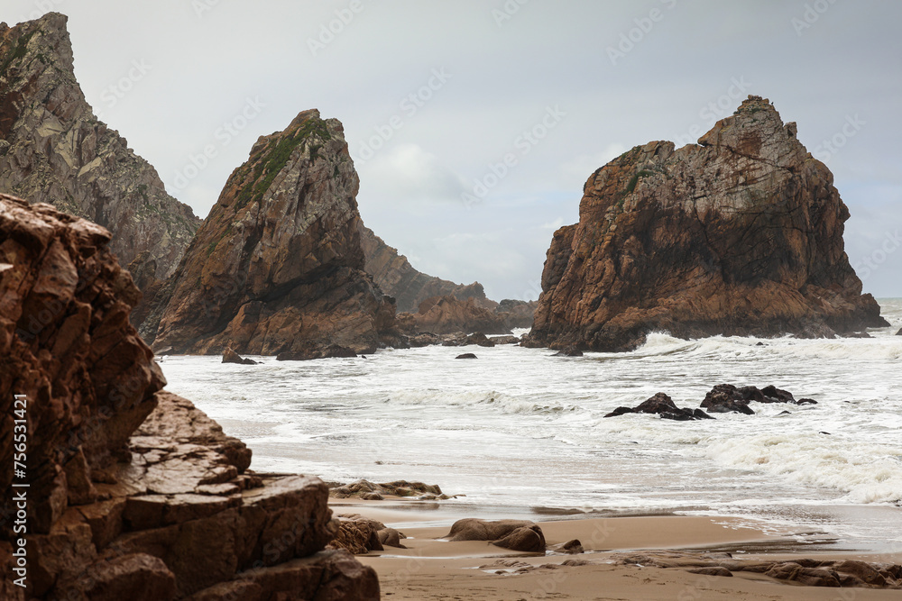 Beach at nervous Atlantic Ocean with big waves before a storm. Photo from Ursa Beach in Portugal. Beach at nervous Atlantic Ocean with big waves before a storm. Photo from Ursa Beach in Portugal.