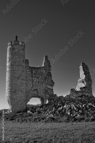 Photography Black and white photograph of the ruins of the castle in the abandoned town of Caudilla, Toledo (Spain), with the figure of a Christ on top of a tower